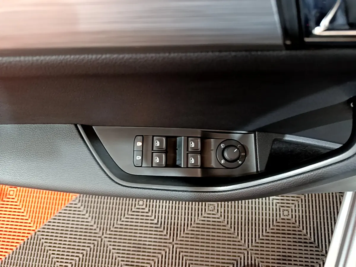 Commandes électriques des vitres et réglage des rétroviseurs sur la porte côté conducteur d'une Skoda Superb gris clair 2020.