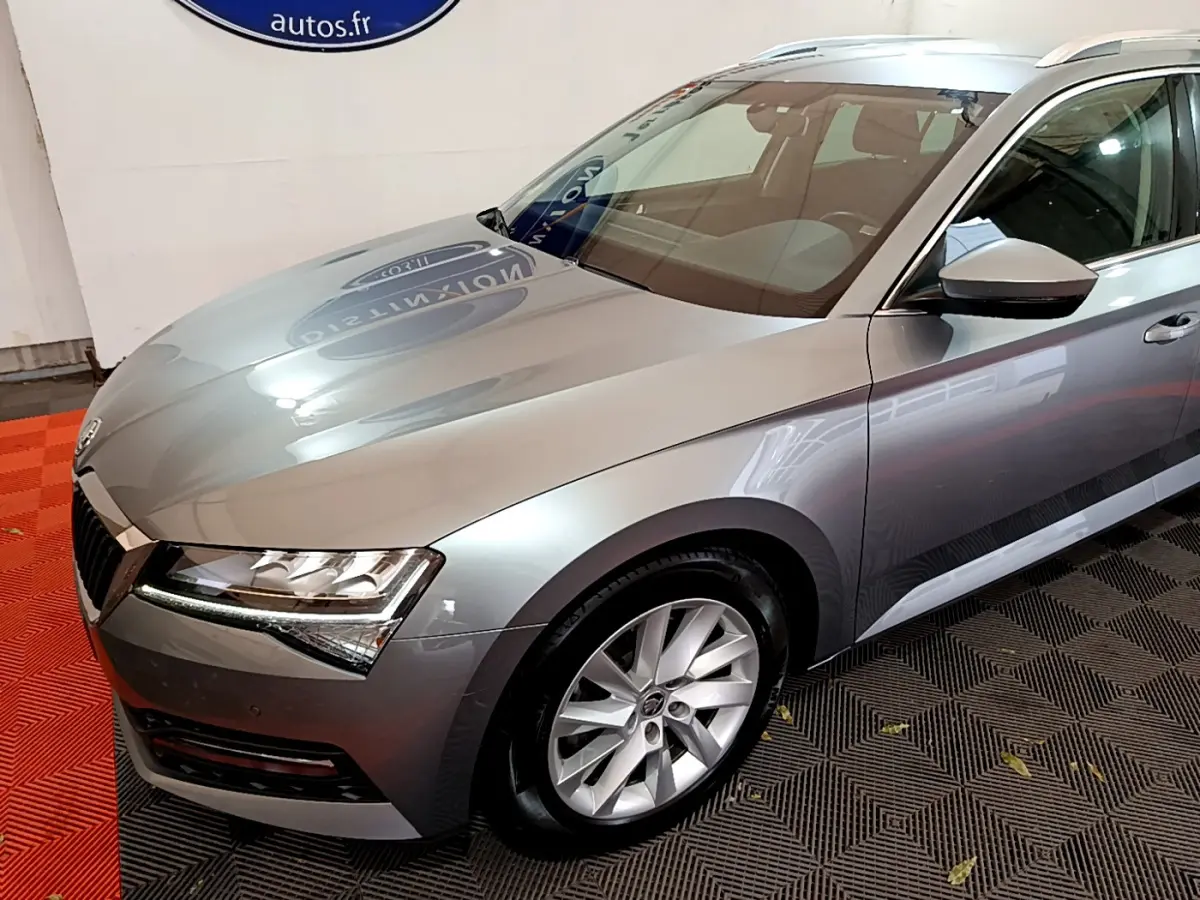 Vue 3/4 avant droit d'une Skoda Superb gris clair 2020 avec phares LED et jantes alliage visibles.