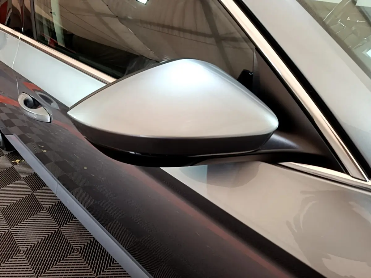 Rétroviseur côté gauche gris clair de la Skoda Superb 2020, avec poignée de porte et partie de la portière visible.