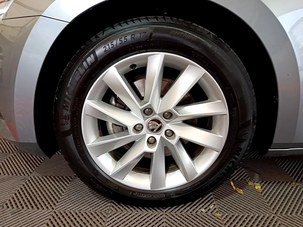 Gros plan sur la roue avant gauche gris clair de la Skoda Superb 2020 avec jante alliage et logo au centre