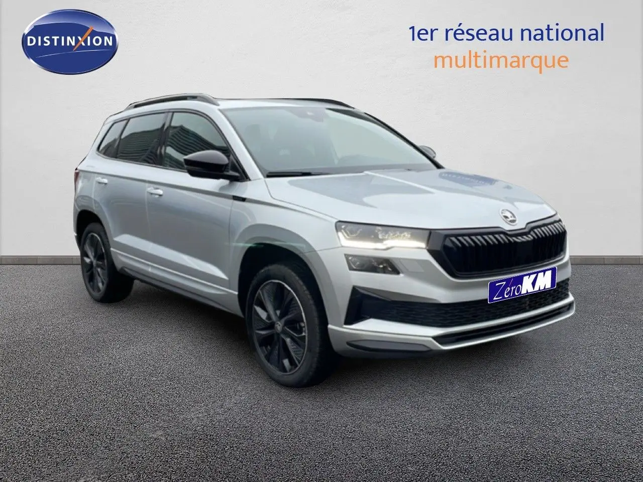 Vue 3/4 avant d'un Skoda Karoq gris argent métallisé avec jantes noires et calandre noire sportive.
