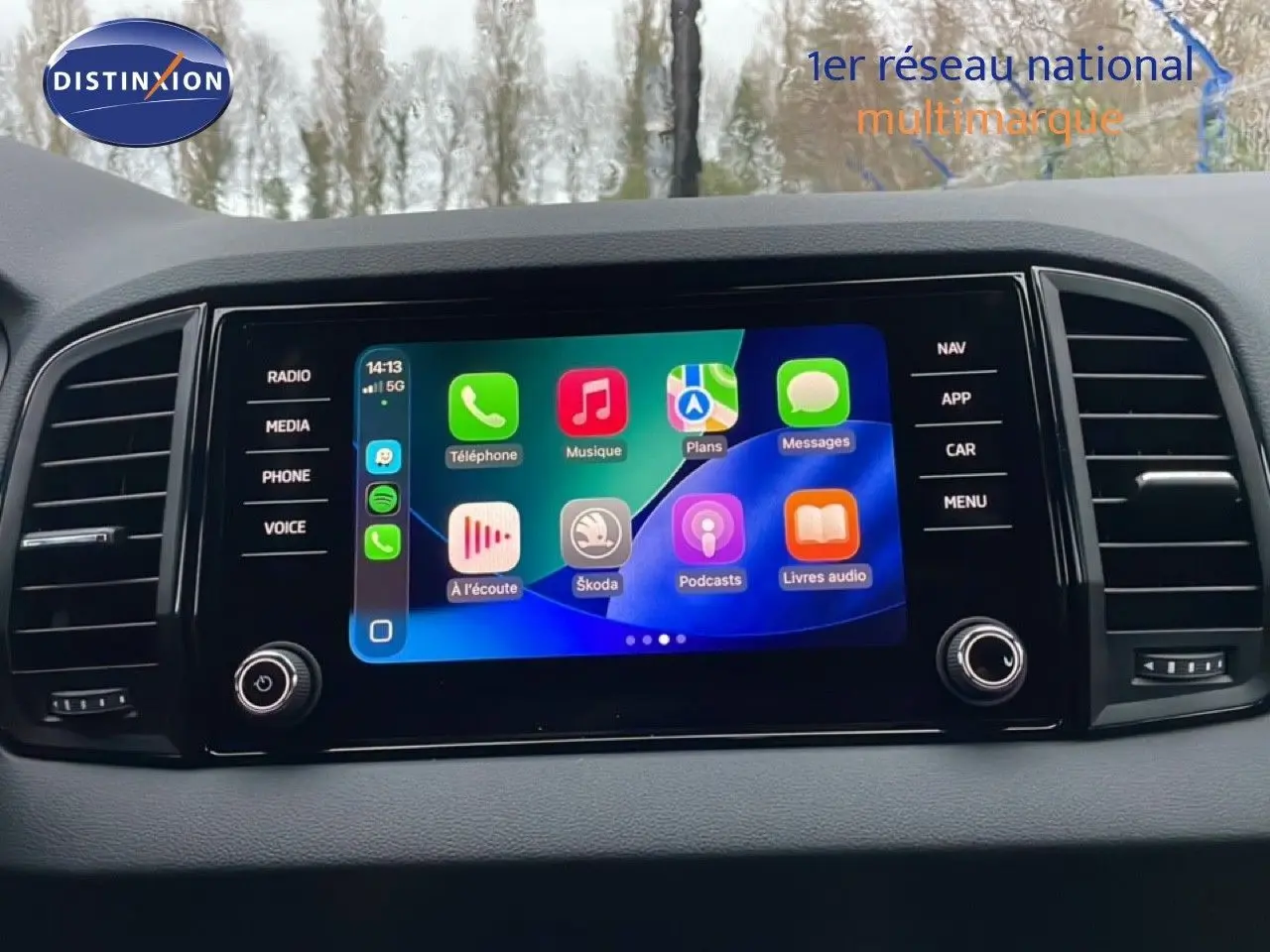 Écran tactile central du Skoda Karoq 2025 affichant les applications multimédias, entouré de commandes noires.