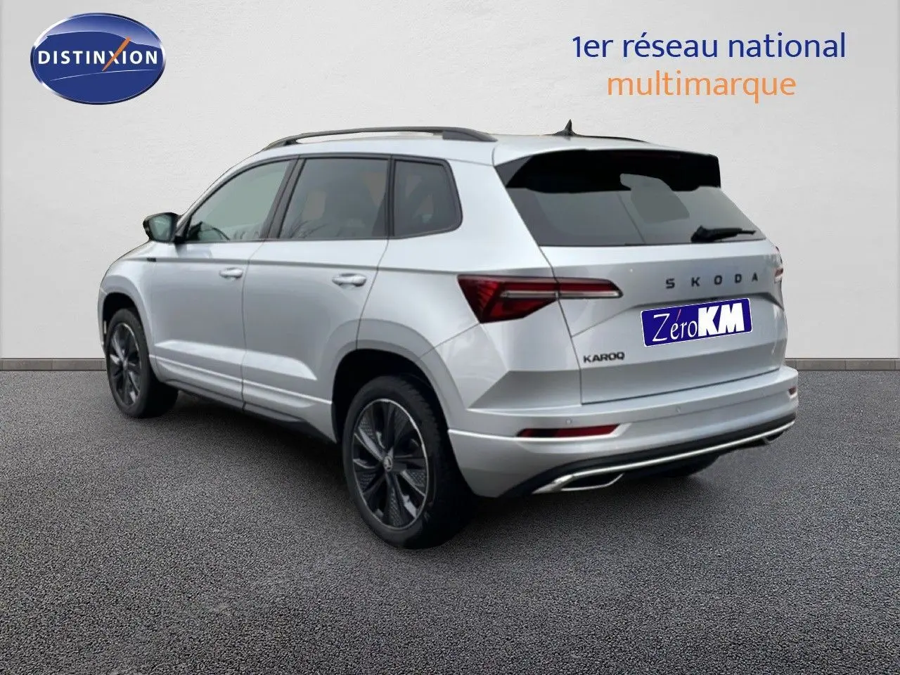Vue 3/4 arrière droite d'un Skoda Karoq gris argent métallisé avec jantes noires et vitres teintées.