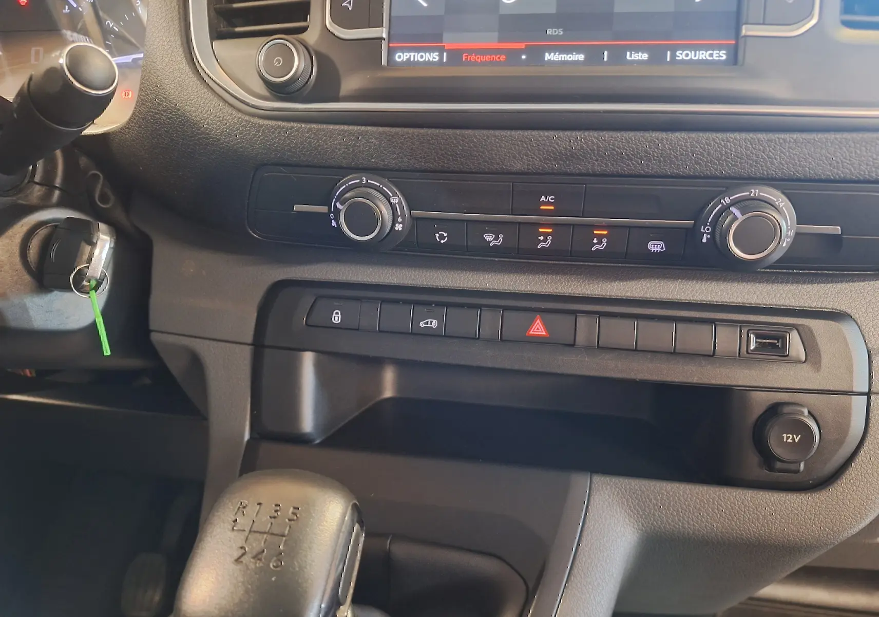 Gros plan sur la console centrale du Citroën Jumpy blanc 2020, avec levier de vitesse manuel et commandes climatisation.