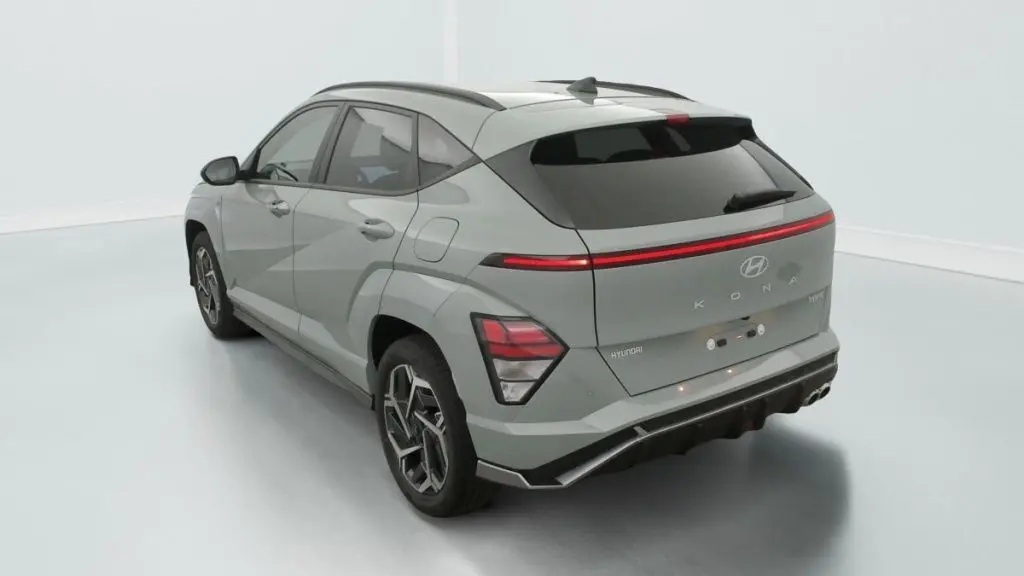 Vue 3/4 arrière droite d'un Hyundai Kona Hybrid 2025 en Mirage Green avec feux arrière LED et toit panoramique noir.