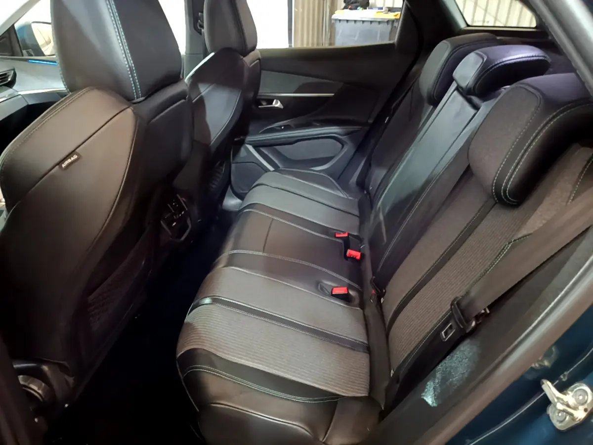 Vue intérieure côté droit des sièges arrière noirs en cuir et tissu du Peugeot 3008 hybride rechargeable bleu 2021.