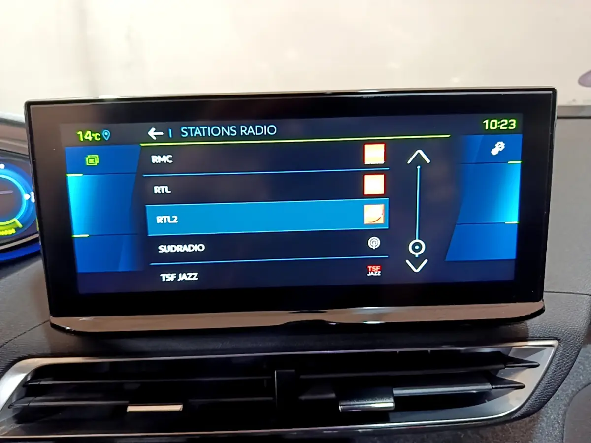 Écran tactile central du tableau de bord du Peugeot 3008 bleu, affichant la liste des stations radio.