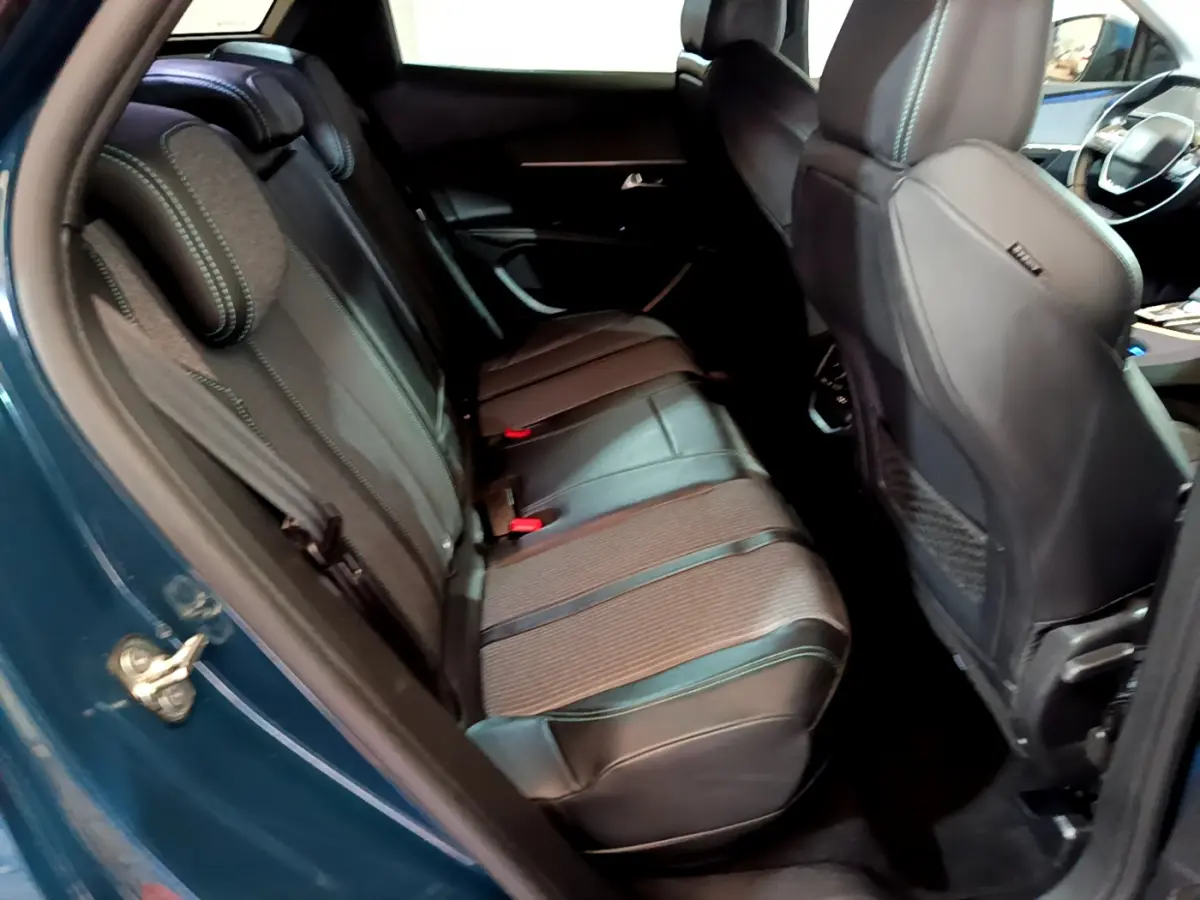Vue intérieure côté gauche sur la banquette arrière en cuir noir avec surpiqûres bleues du Peugeot 3008 bleu hybride rechargeable 2021