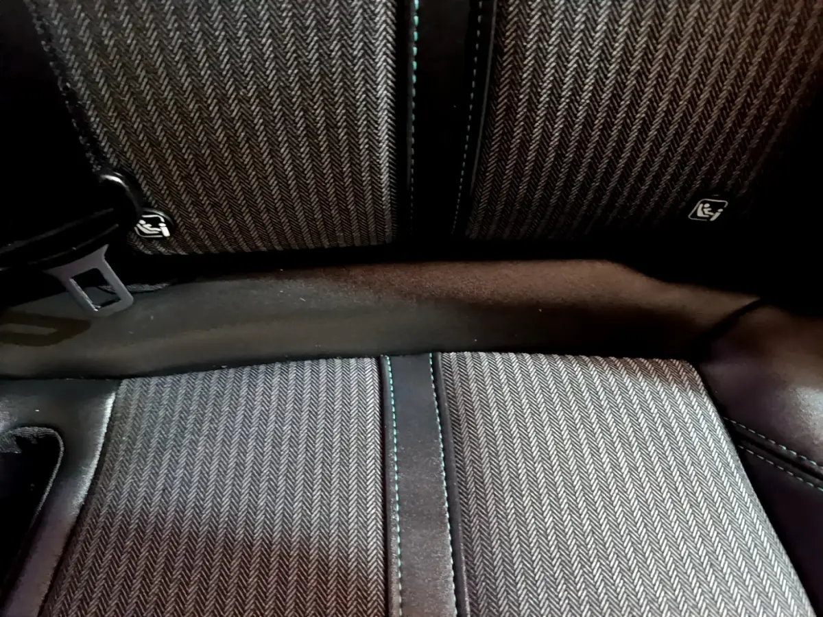 Gros plan sur la banquette arrière en tissu gris à motif chevrons du Peugeot 3008 hybride rechargeable.