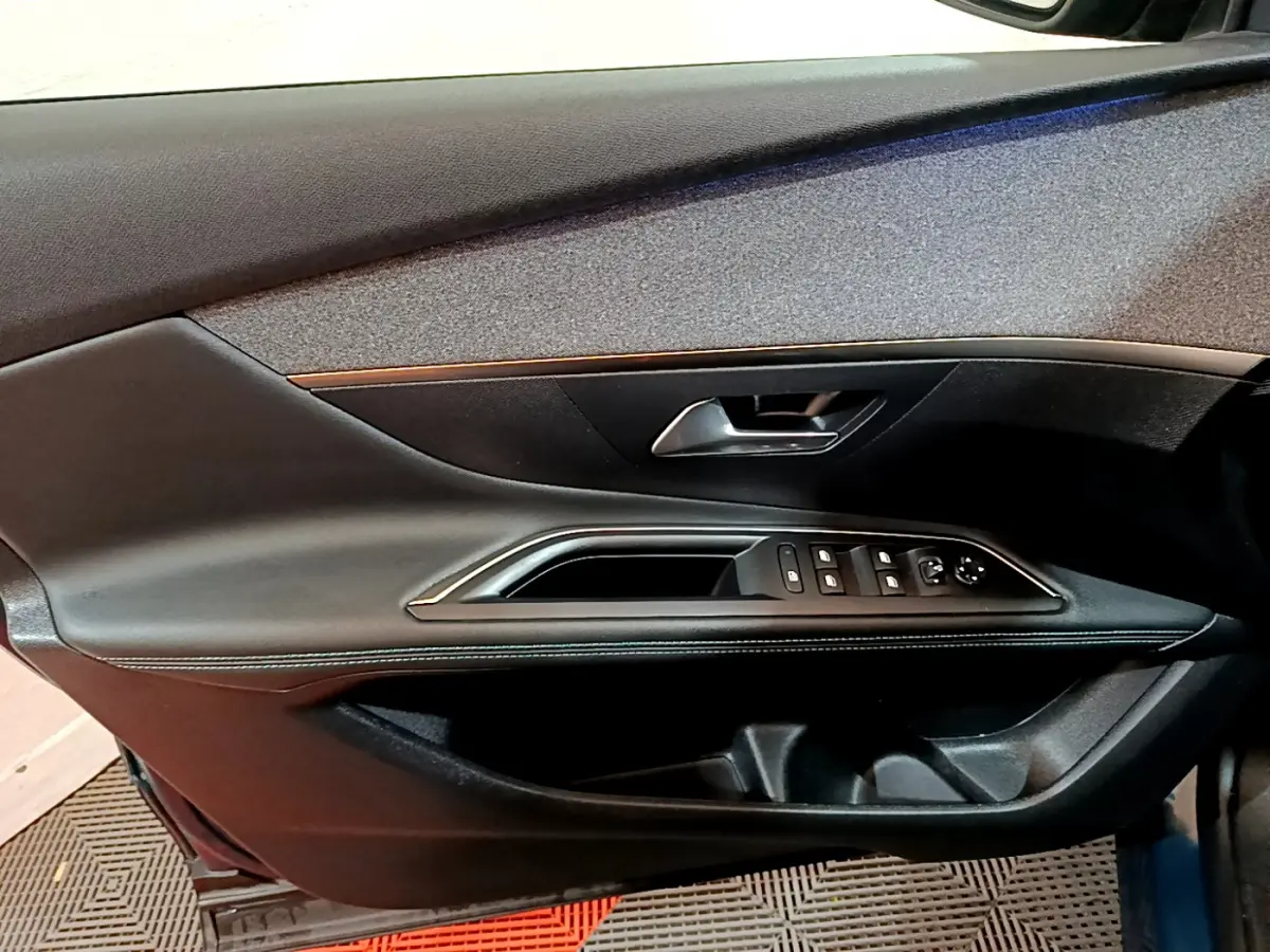 Intérieur côté gauche de la porte PEUGEOT 3008 bleu, avec commandes électriques et poignée argentée.