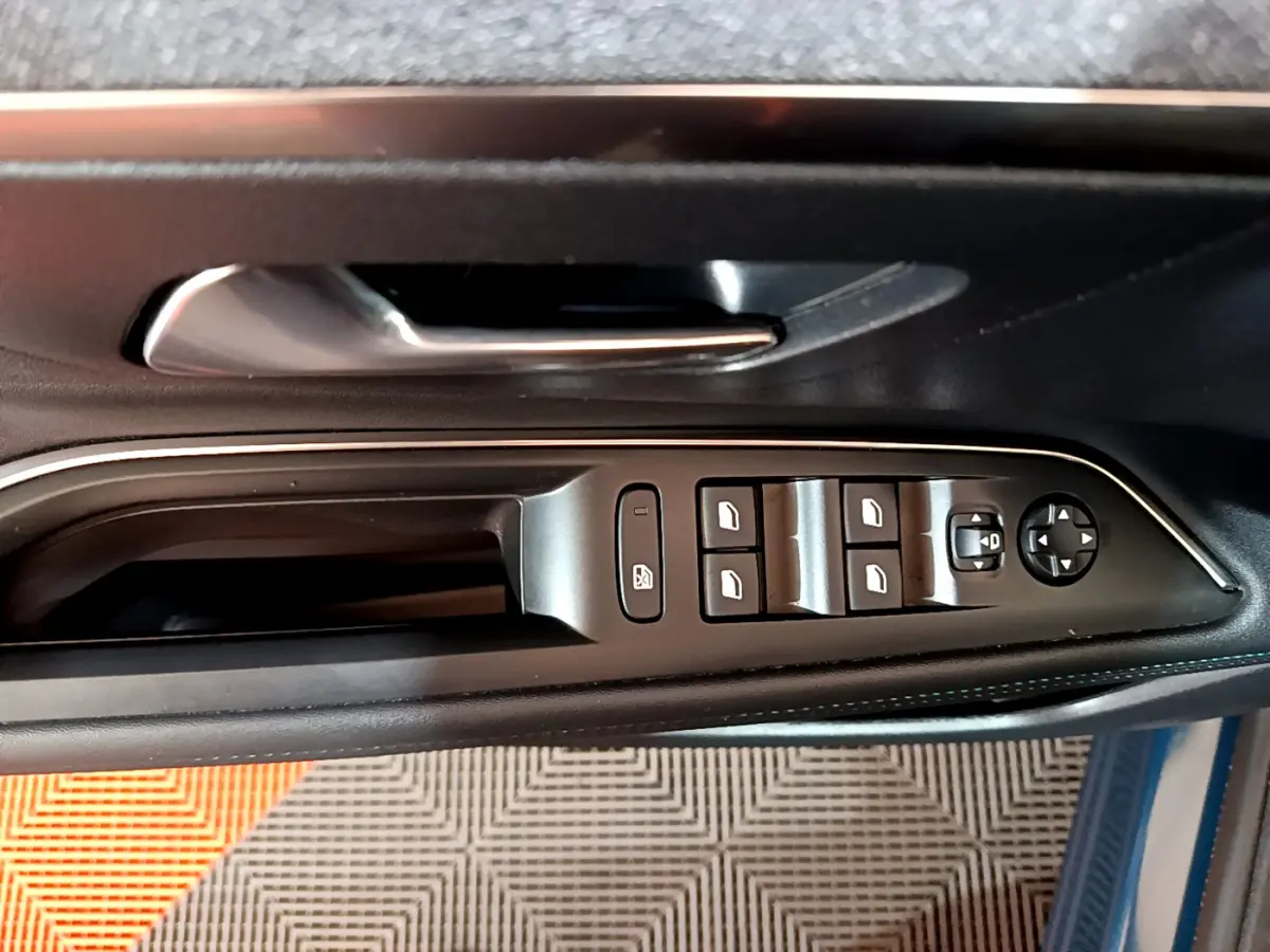 Gros plan sur la commande des vitres et rétroviseurs côté gauche de la porte intérieure noire du Peugeot 3008 bleu hybride.