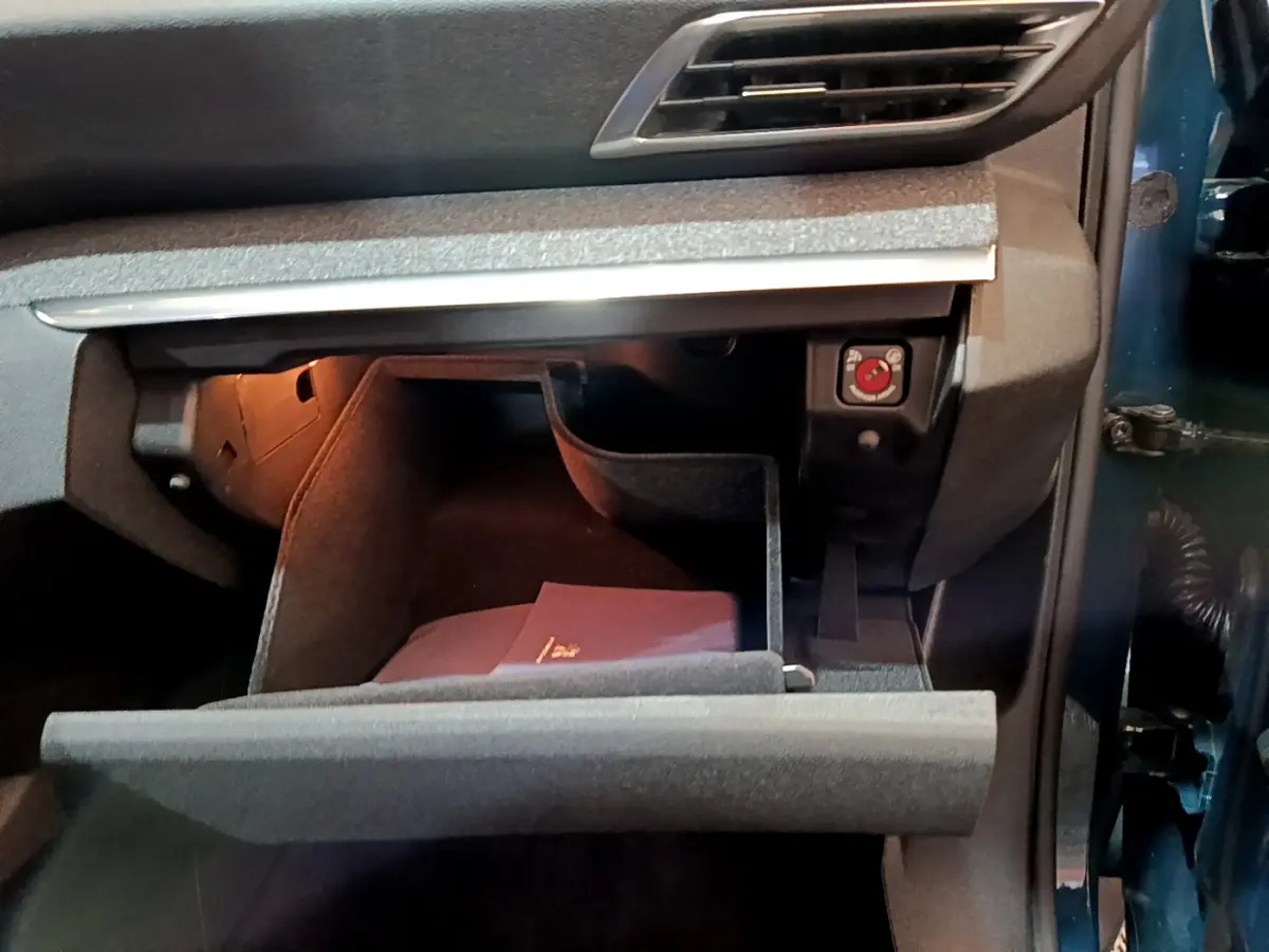 Vue intérieure du coffre à gants ouvert côté passager d'un Peugeot 3008 bleu hybride rechargeable 2021.