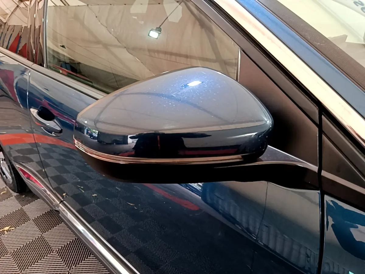 Rétroviseur côté gauche bleu métallisé du Peugeot 3008 hybride 2021, avec poignée de porte et vitre partiellement visibles.