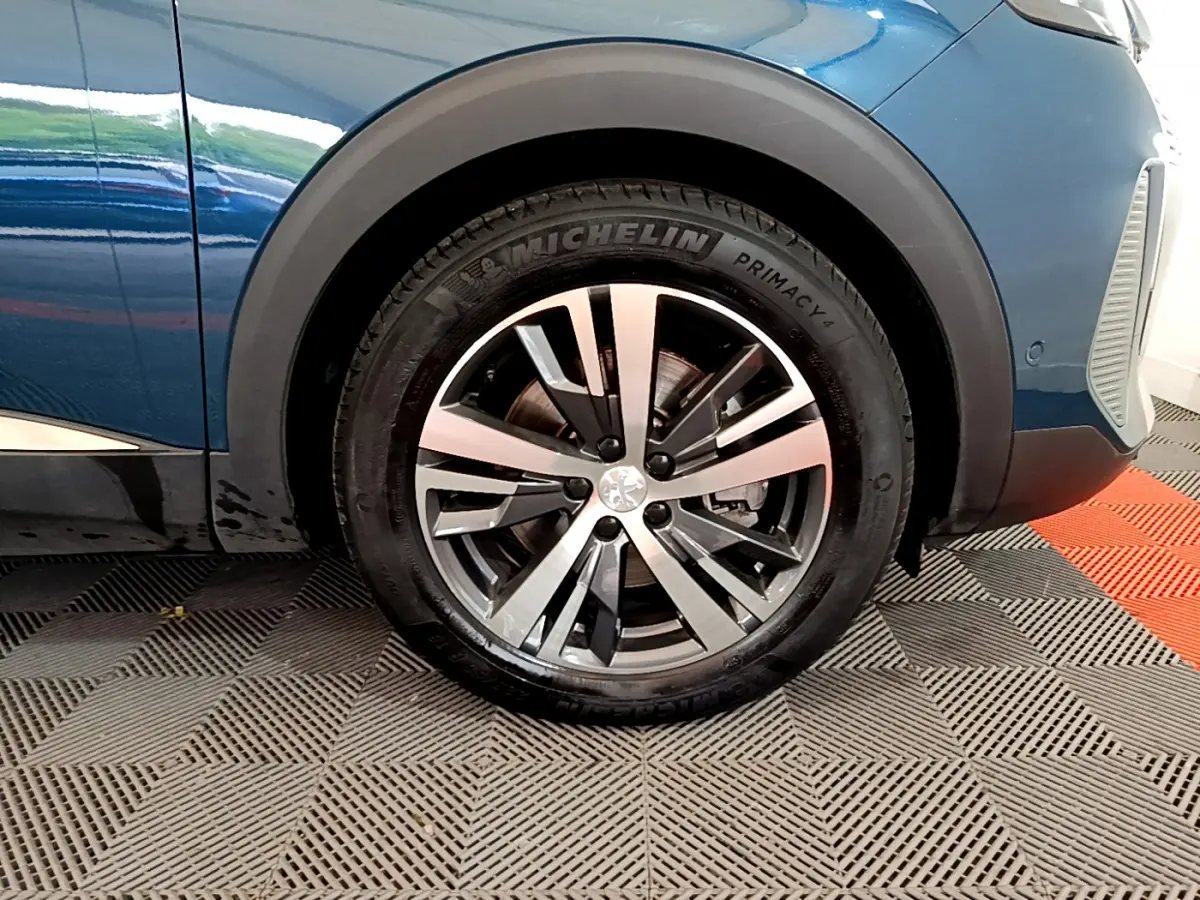 Gros plan sur la roue avant gauche du Peugeot 3008 bleu avec jante alliage et pneu Michelin Primacy.