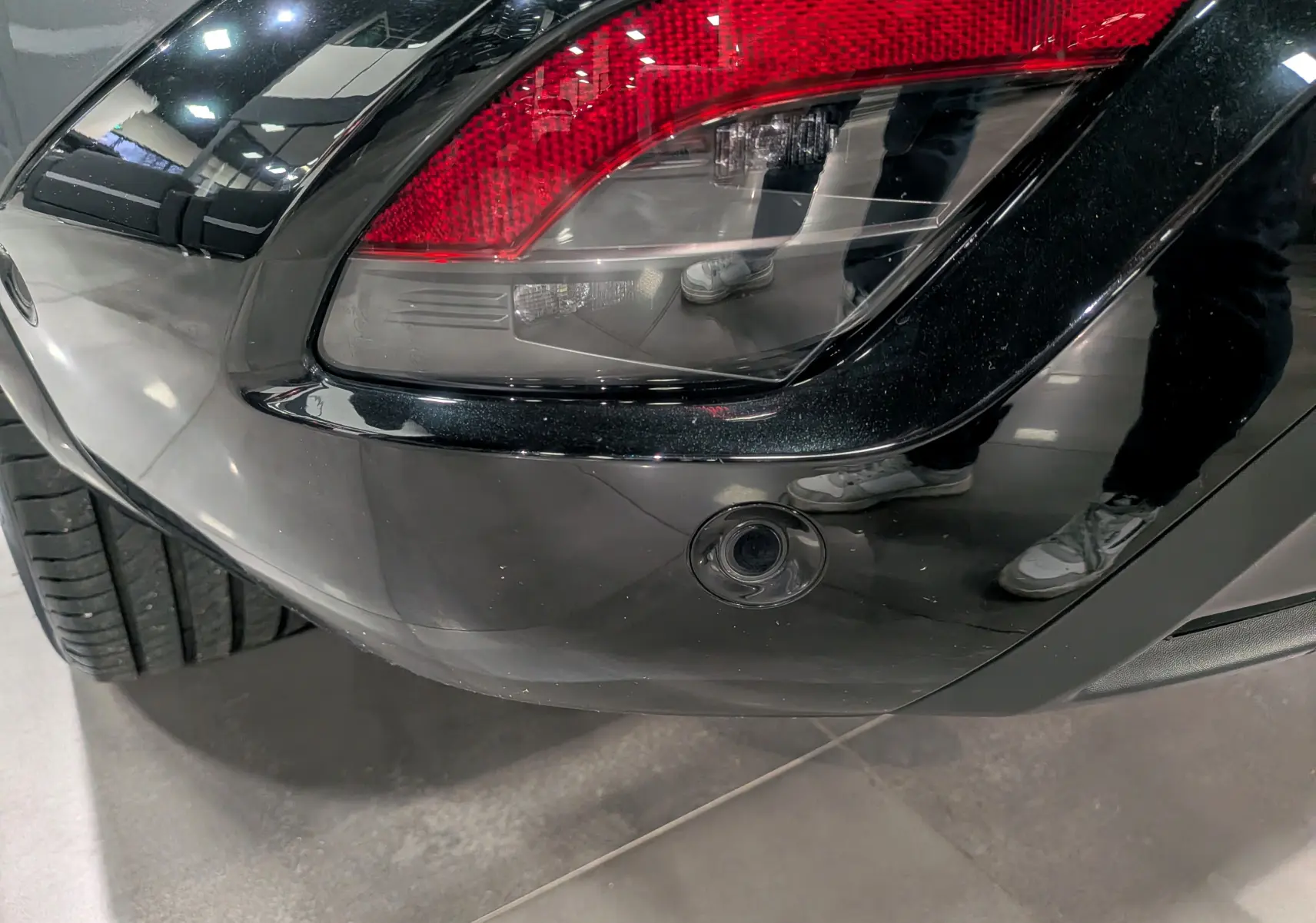 Gros plan sur le feu arrière droit gris schiste du Renault Austral 2024 avec toit noir et capteur de recul intégré.