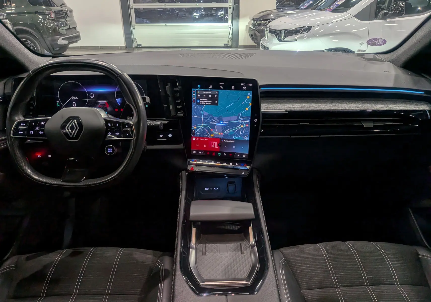 Intérieur du Renault Austral 2024, vue frontale sur tableau de bord noir avec écran tactile central et volant multifonction.