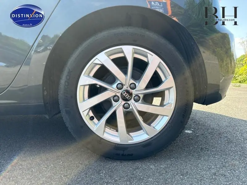 Gros plan sur la jante alu argentée et pneu Hankook de l'Audi A1 Sportback noir Mythic métallisé côté arrière droit.