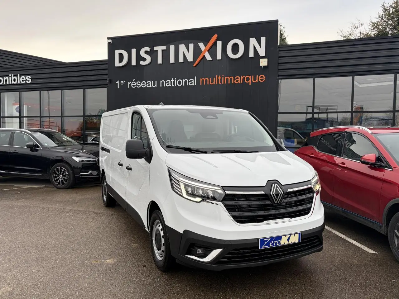 Renault Trafic Fourgon blanc glacier en 3/4 avant droit, avec projecteurs Full LED et calandre noire distinctive.