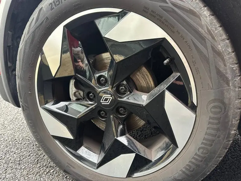 Gros plan sur la jante noire et argentée au design étoilé du Renault Captur Rouge Flamme/Noir Etoilé 2025.