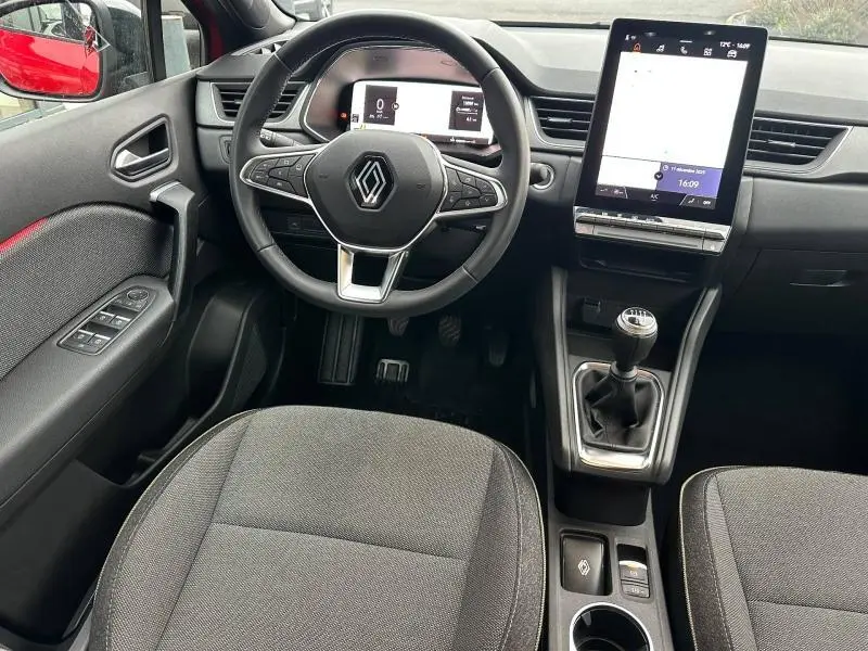 Vue intérieure avant du Renault Captur 2025, volant multifonction, écran tactile vertical et levier de vitesse manuel.