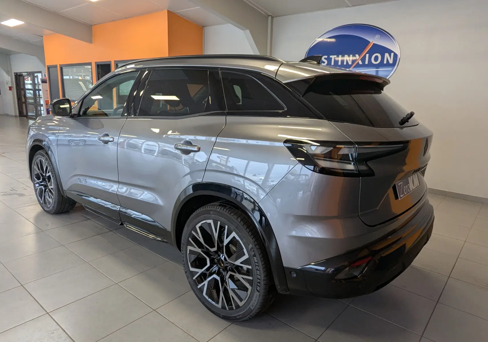 Vue 3/4 arrière droite du Renault Austral gris schiste avec jantes noires diamantées en showroom.