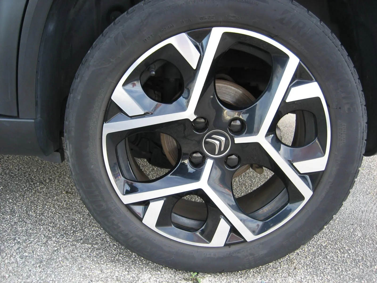 Gros plan sur la jante noire et argentée avec logo Citroën du SUV gris platinium C3 Aircross 2022.