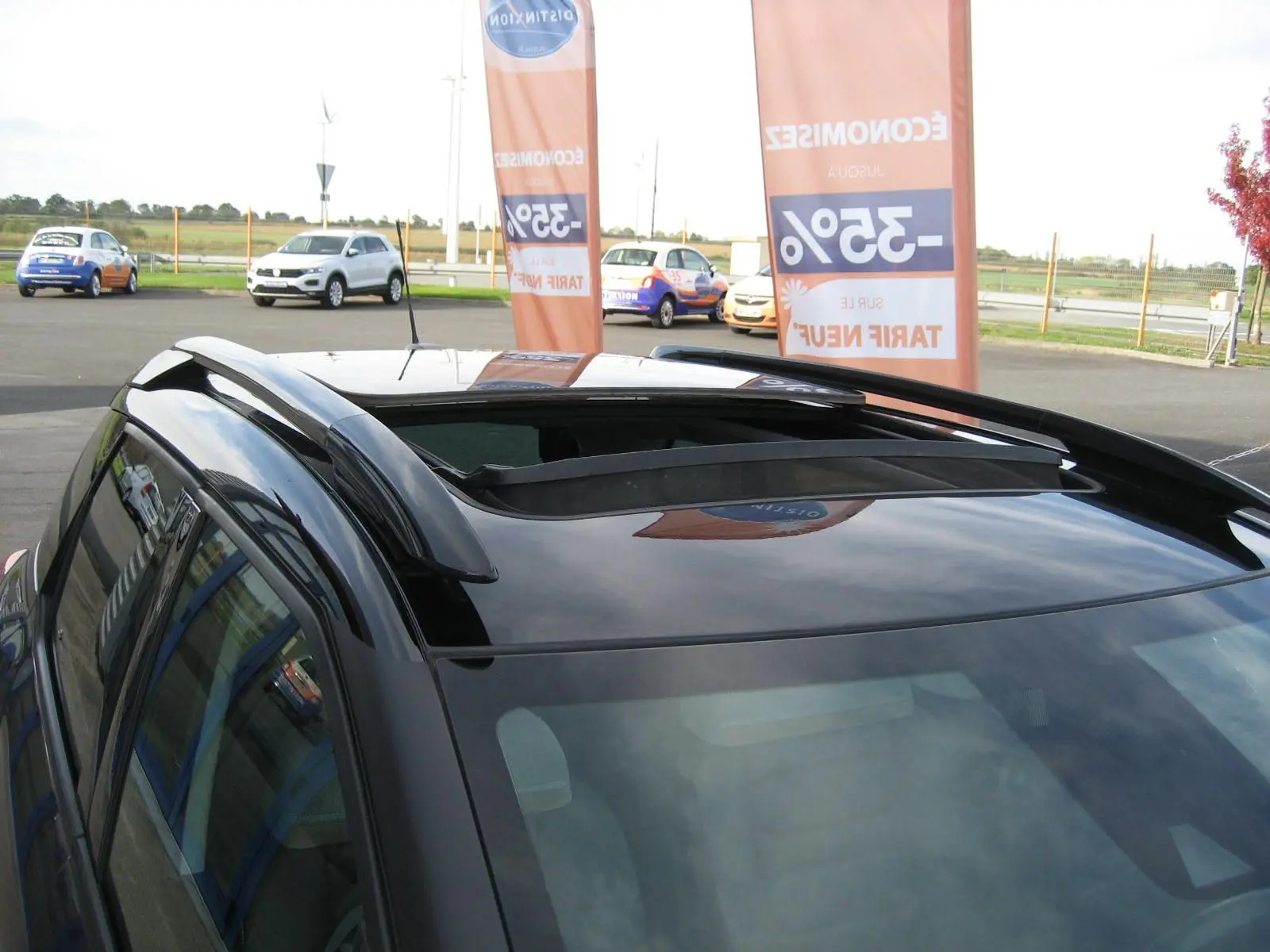 Toit ouvrant panoramique ouvert sur le dessus d'un Citroën C3 Aircross gris platinium vu en léger contre-plongée.