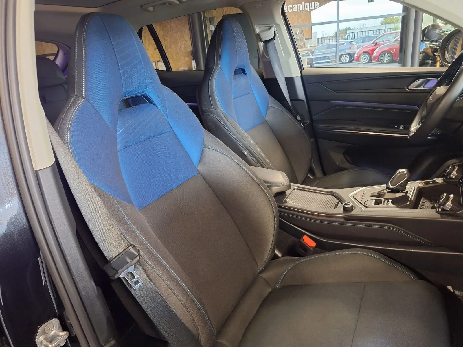 Intérieur du Lynk & Co 01 2023 vu côté gauche, sièges tissu noir et bleu avec console centrale moderne.