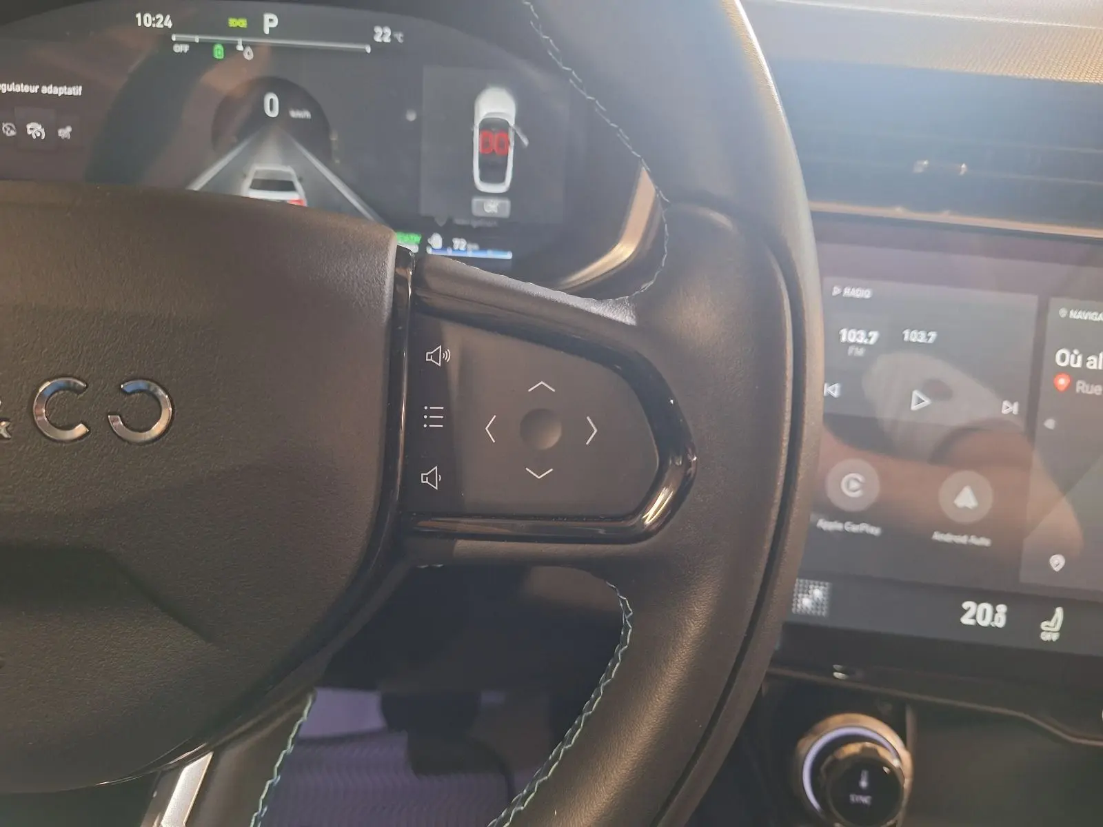 Gros plan sur le volant noir du Lynk & Co 01 hybride rechargeable, avec commandes tactiles et tableau de bord numérique visible.