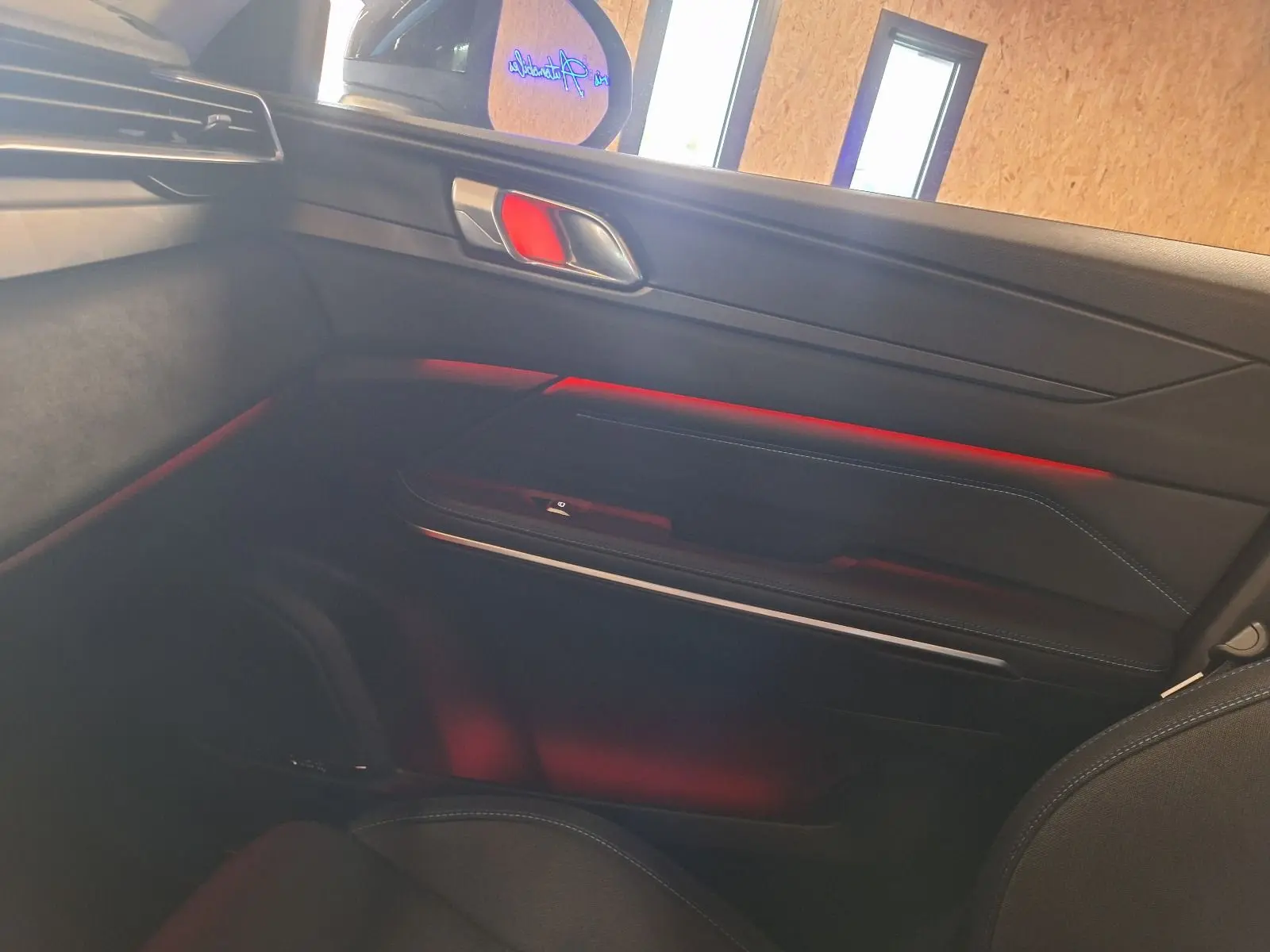 Intérieur côté droit du LYNK & CO 01 noir 2023, avec éclairage d'ambiance rouge et garnitures modernes.