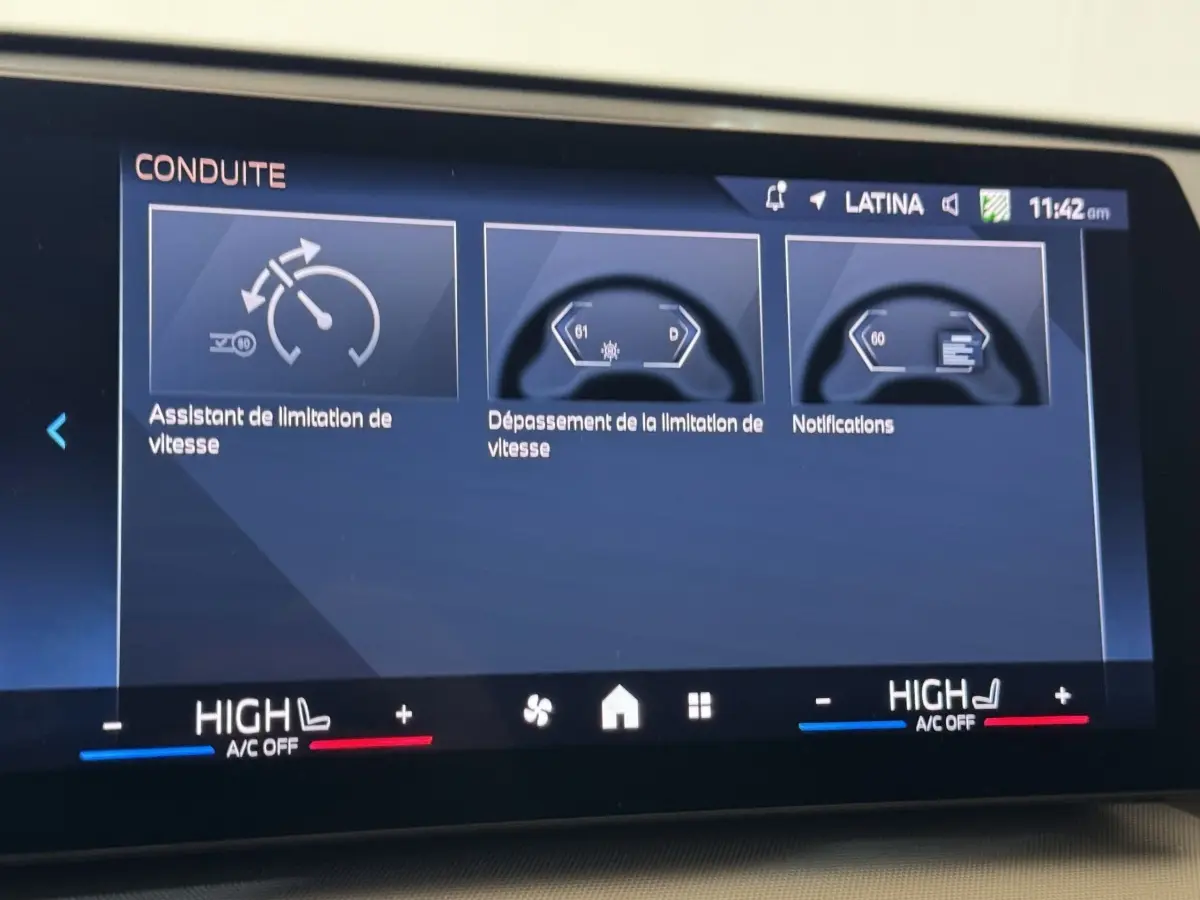 Écran tactile intérieur affichant l’aide à la conduite sur BMW X1 gris foncé, vue du tableau de bord central.