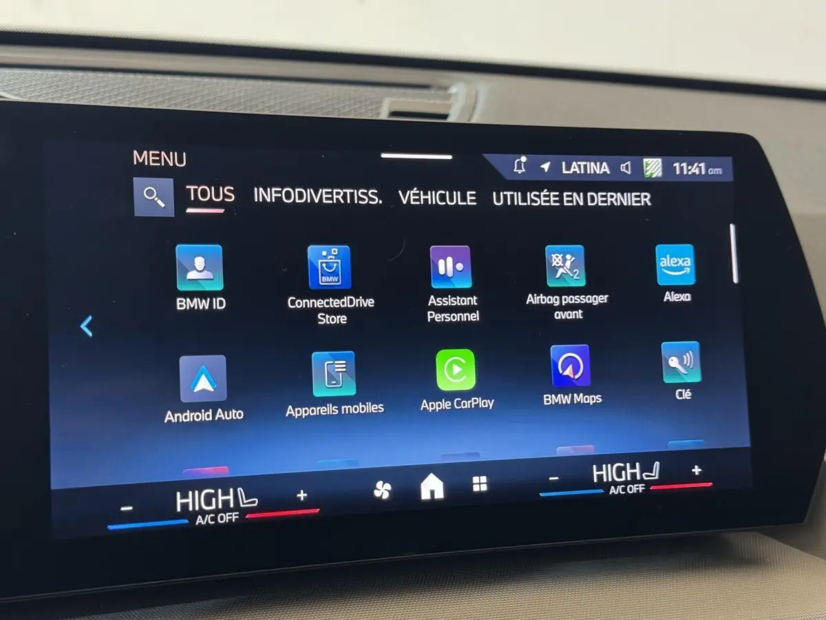 Écran tactile central du BMW X1 2024 affichant les applications connectées et commandes climatisation en intérieur.