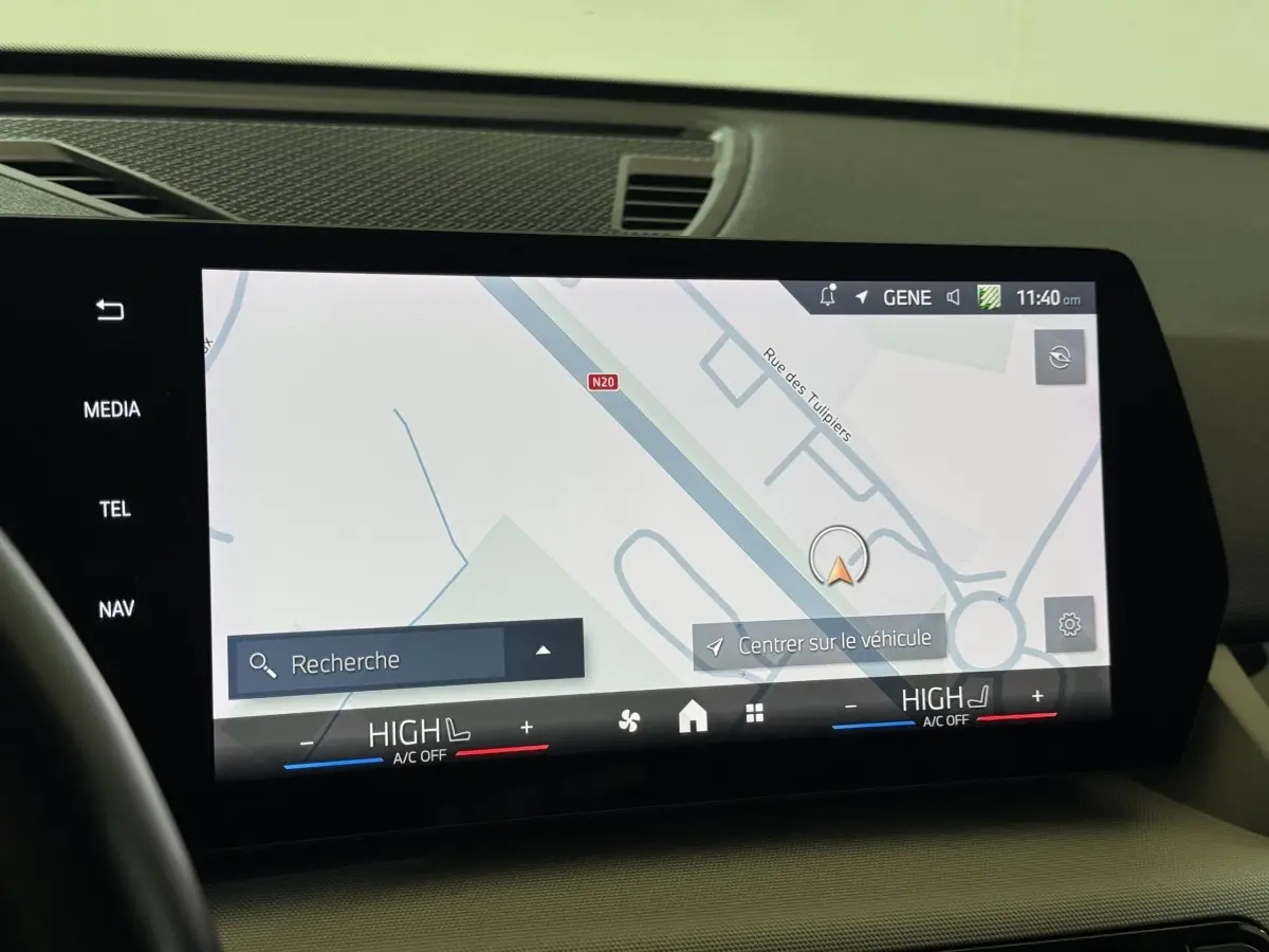 Écran tactile central du tableau de bord du BMW X1 2024 affichant la navigation et les commandes de climatisation.