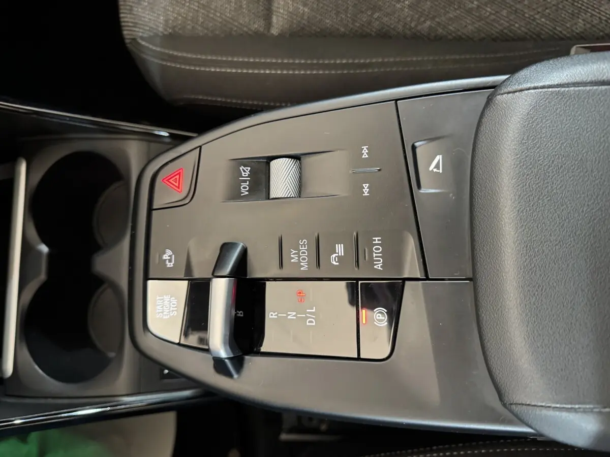 Vue en plongée sur la console centrale gris foncé du BMW X1 2024 avec commandes de boîte auto et bouton start/stop.