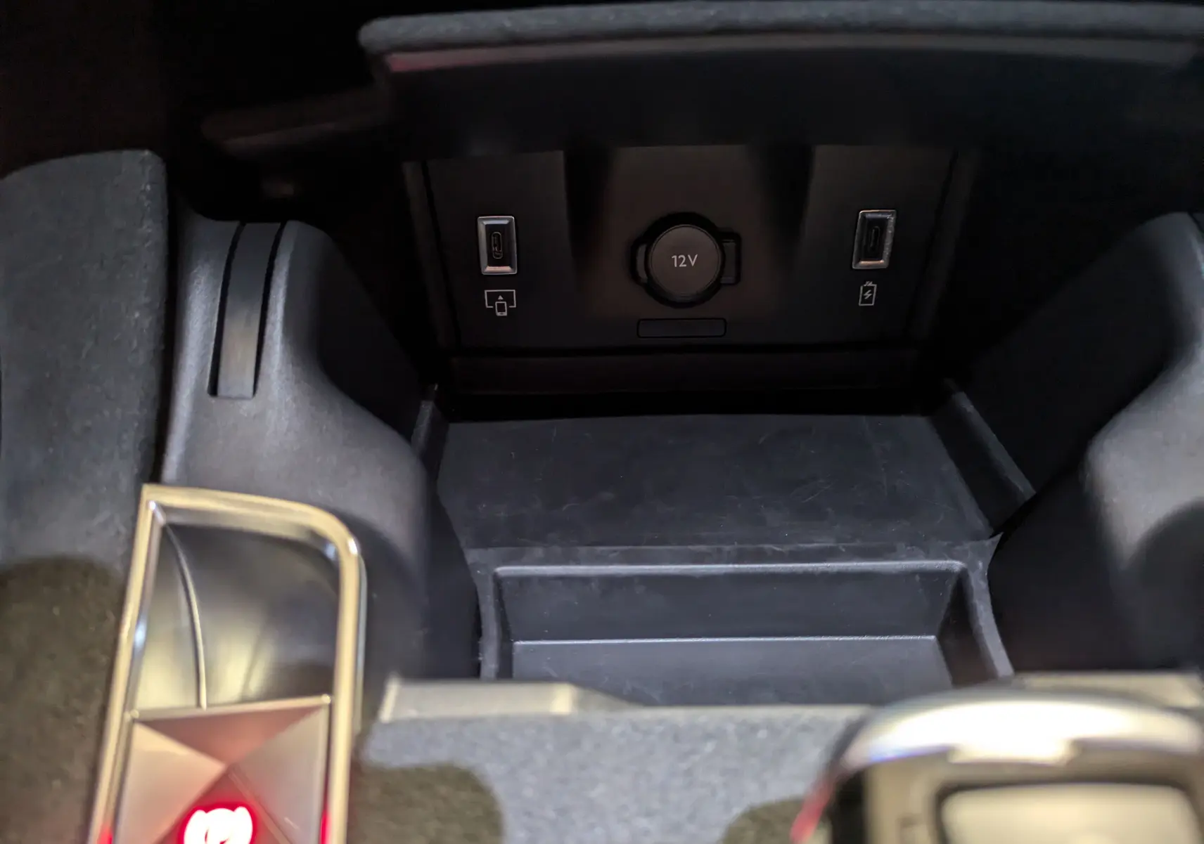 Gros plan sur la console centrale du DS7 2023, montrant prises USB Type-C et prise 12V dans un intérieur noir Alcantara.