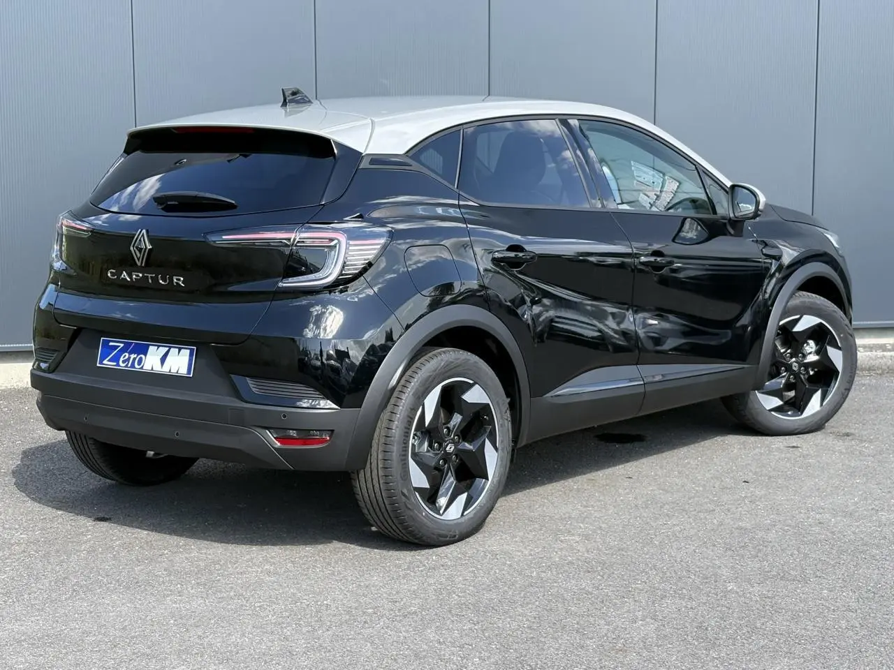 Renault Captur 2025 noir étoilé en 3/4 arrière droit avec jantes aluminium Black Hole et toit beige perle.