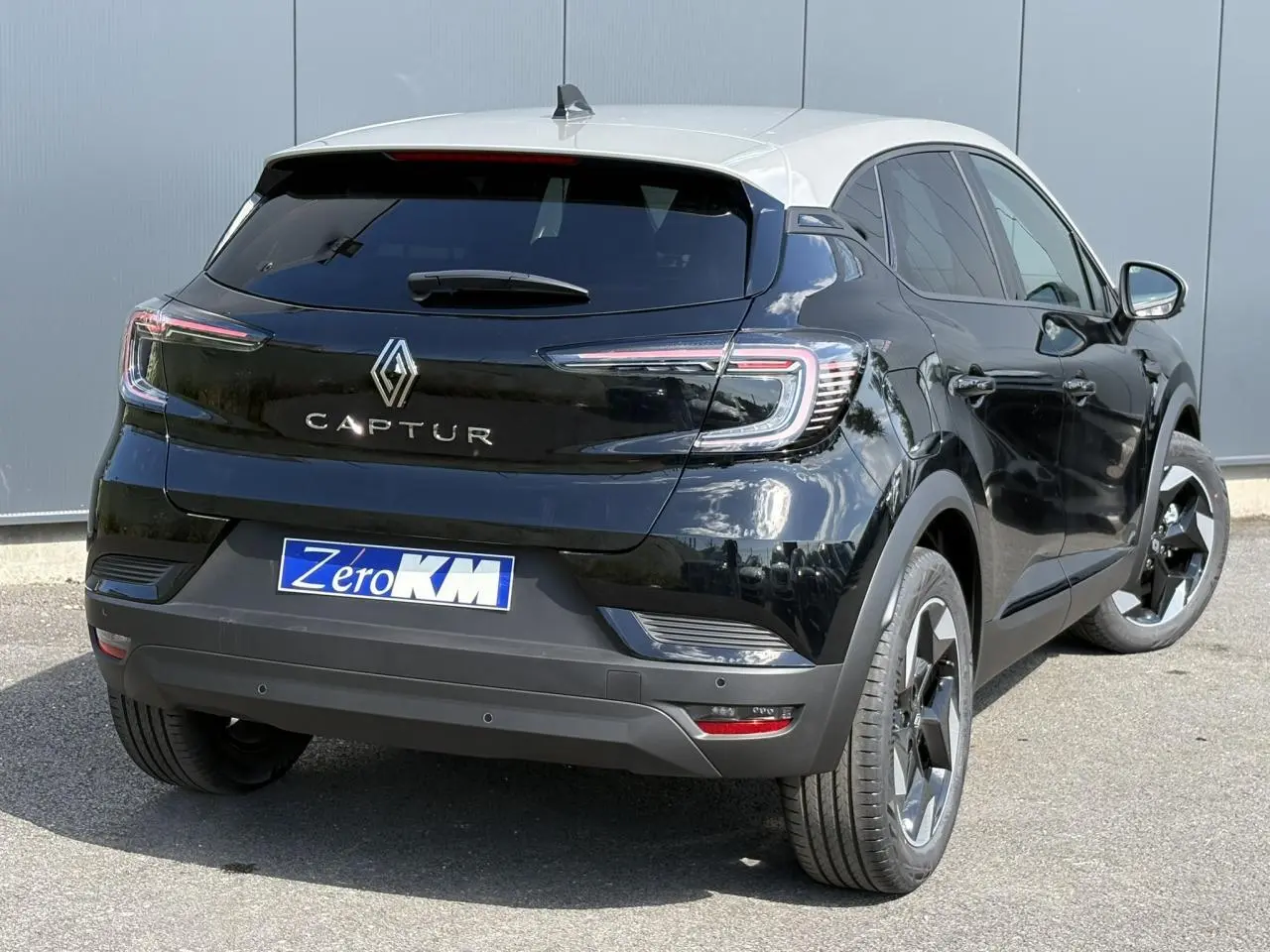 Renault Captur noir étoilé avec toit beige perle, vue 3/4 arrière droit, jantes aluminium 18 pouces Black Hole.