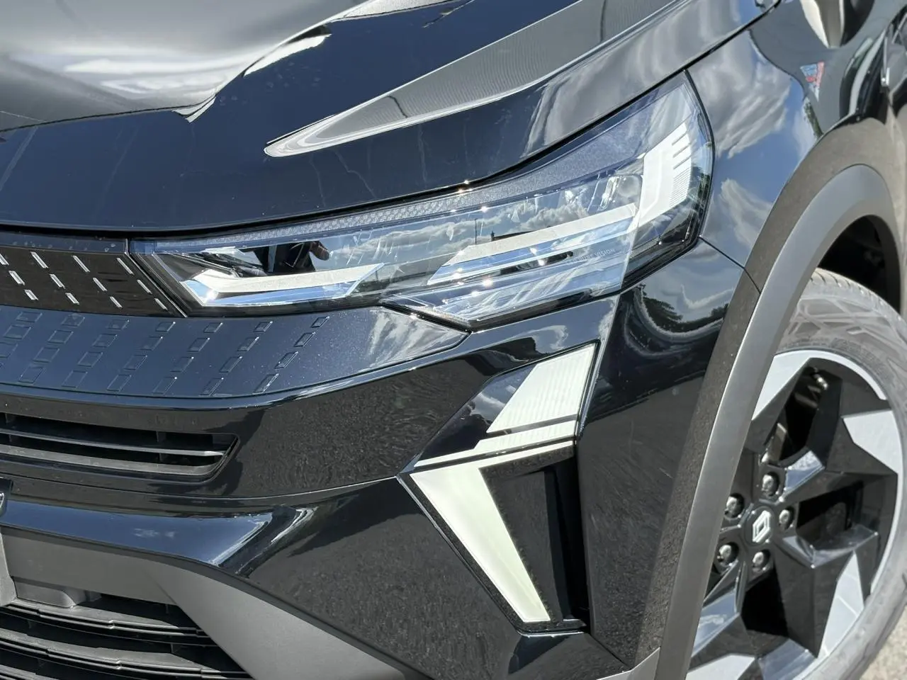 Gros plan sur l'avant droit noir étoilé du Renault Captur 2025 avec ses phares LED et jantes aluminium distinctives.