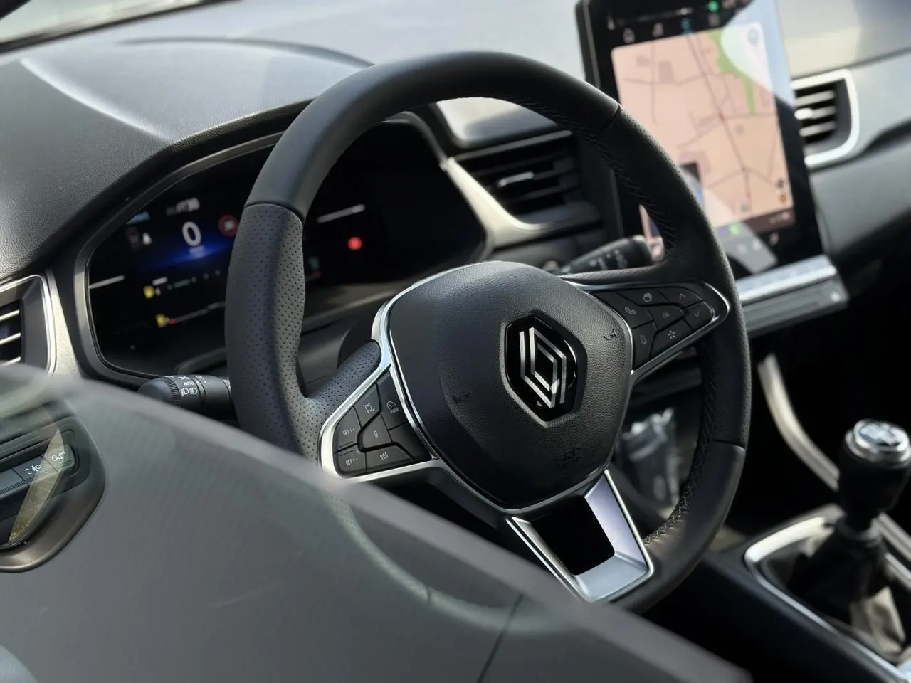 Volant en cuir noir avec commandes intégrées et écran tactile vertical du tableau de bord du Renault Captur 2025.