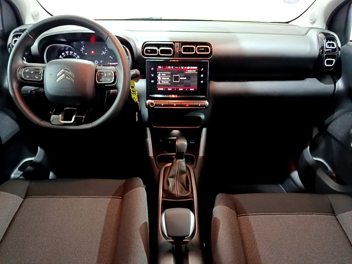 Intérieur Citroën C3 Aircross 2019 vu de face, tableau de bord noir avec écran tactile central et volant cuir multifonctions.