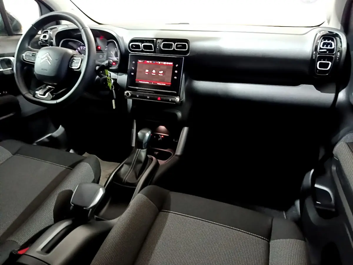 Vue intérieure avant du Citroën C3 Aircross 2019, tableau de bord noir avec écran tactile central et volant multifonctions.