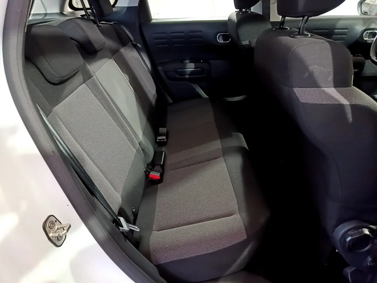 Vue intérieure côté gauche montrant la banquette arrière noire du Citroën C3 Aircross blanc de 2019.