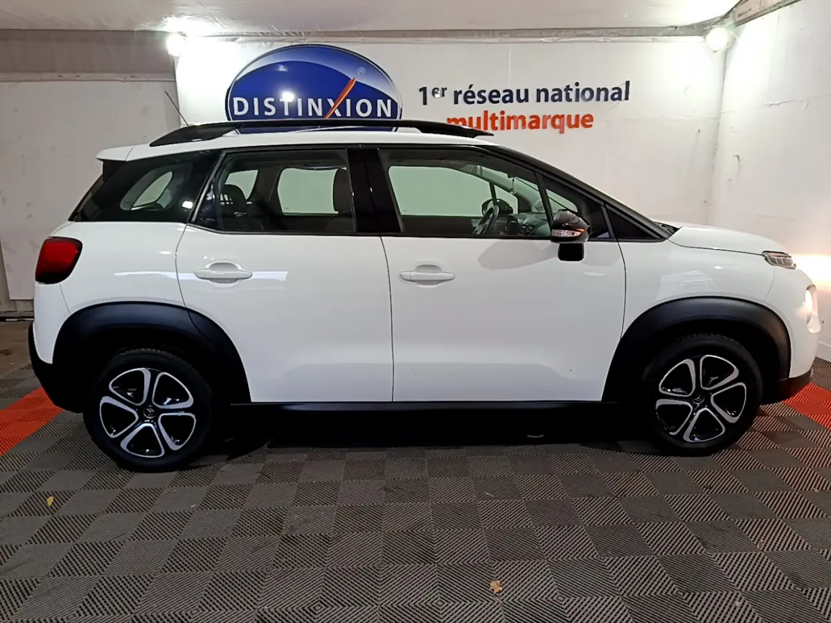 Profil droit d'un Citroën C3 Aircross blanc avec toit noir et jantes distinctives en concession.