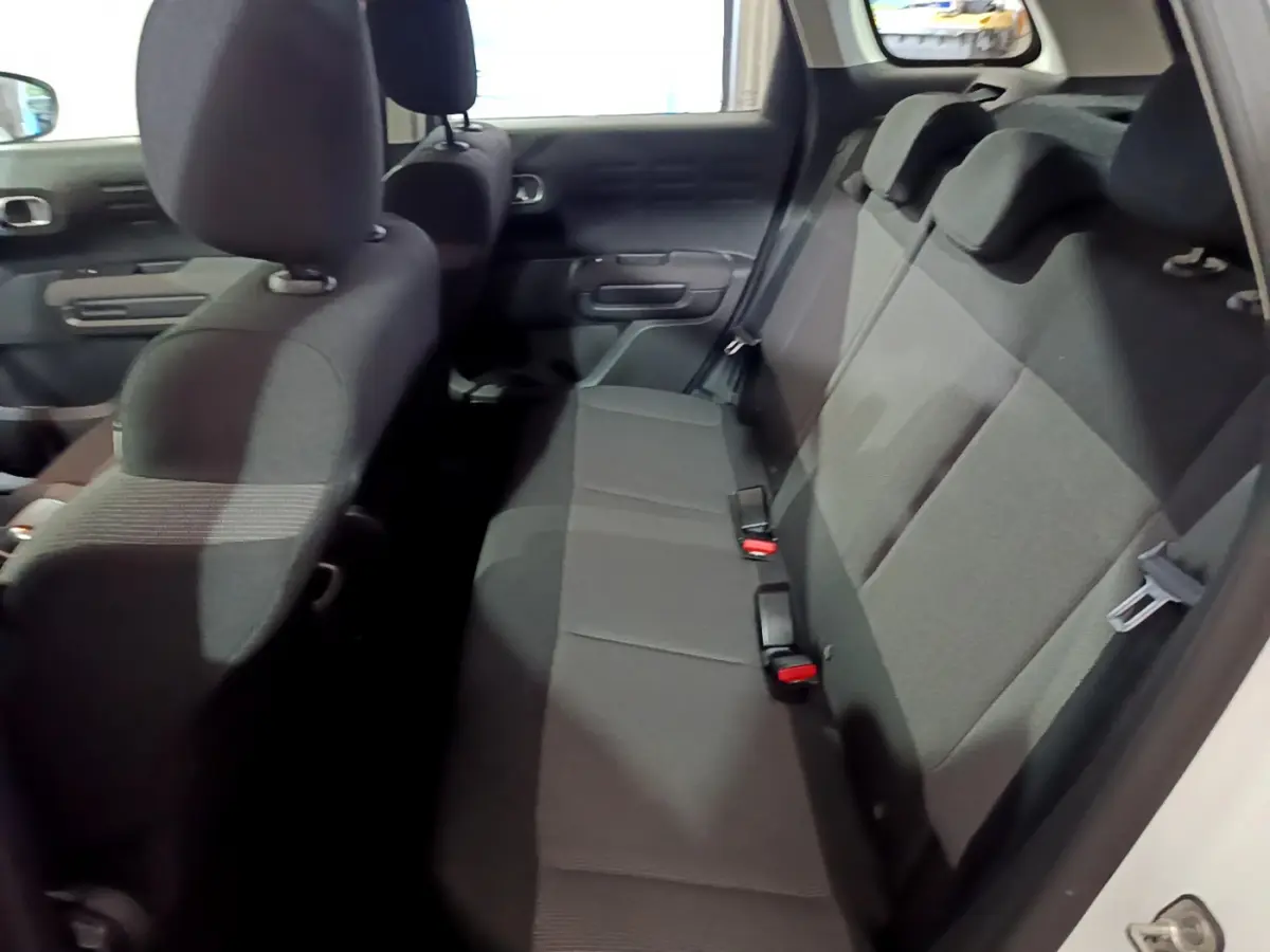 Vue intérieure côté droit montrant la banquette arrière noire du Citroën C3 Aircross blanc 2019.