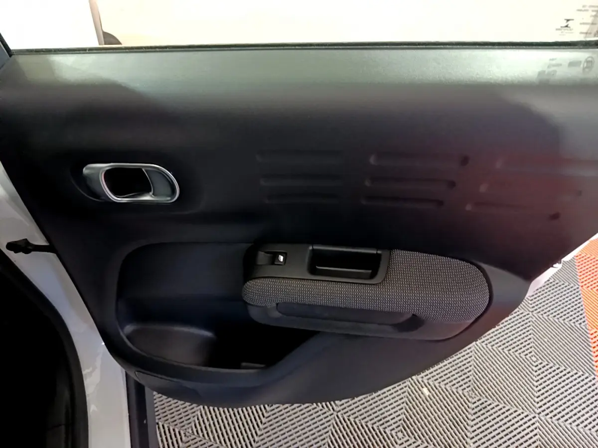 Vue intérieure du panneau de porte avant gauche noir et gris d'une Citroën C3 Aircross blanc 2019.