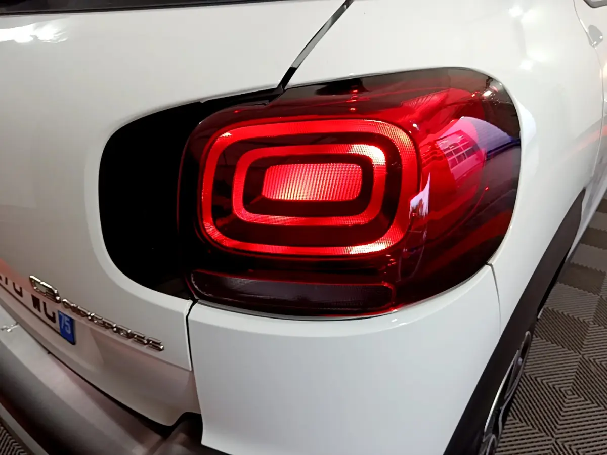 Gros plan sur le feu arrière droit rouge d’une Citroën C3 Aircross blanche, avec partie de la carrosserie visible.