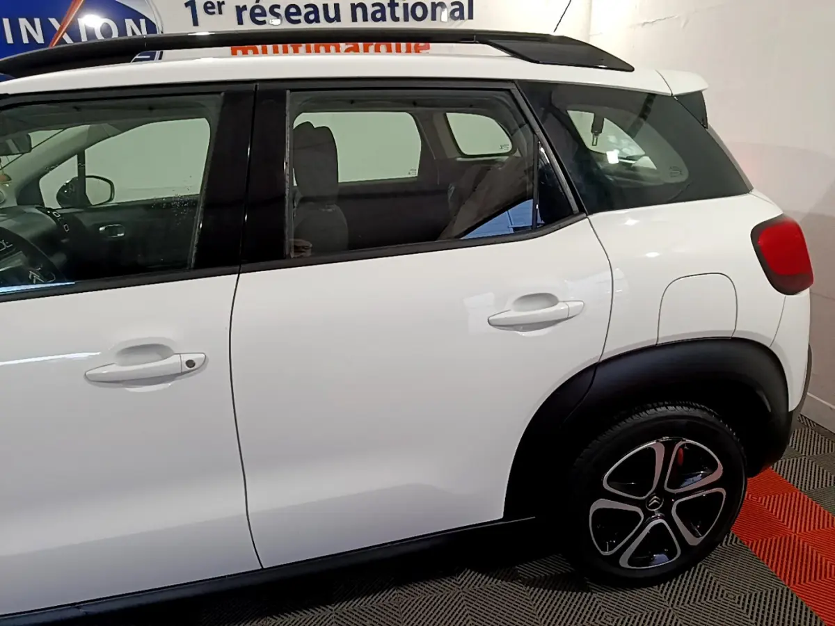 Vue latérale droite d'une Citroën C3 Aircross blanche, avec toit noir et jantes distinctives en alliage.