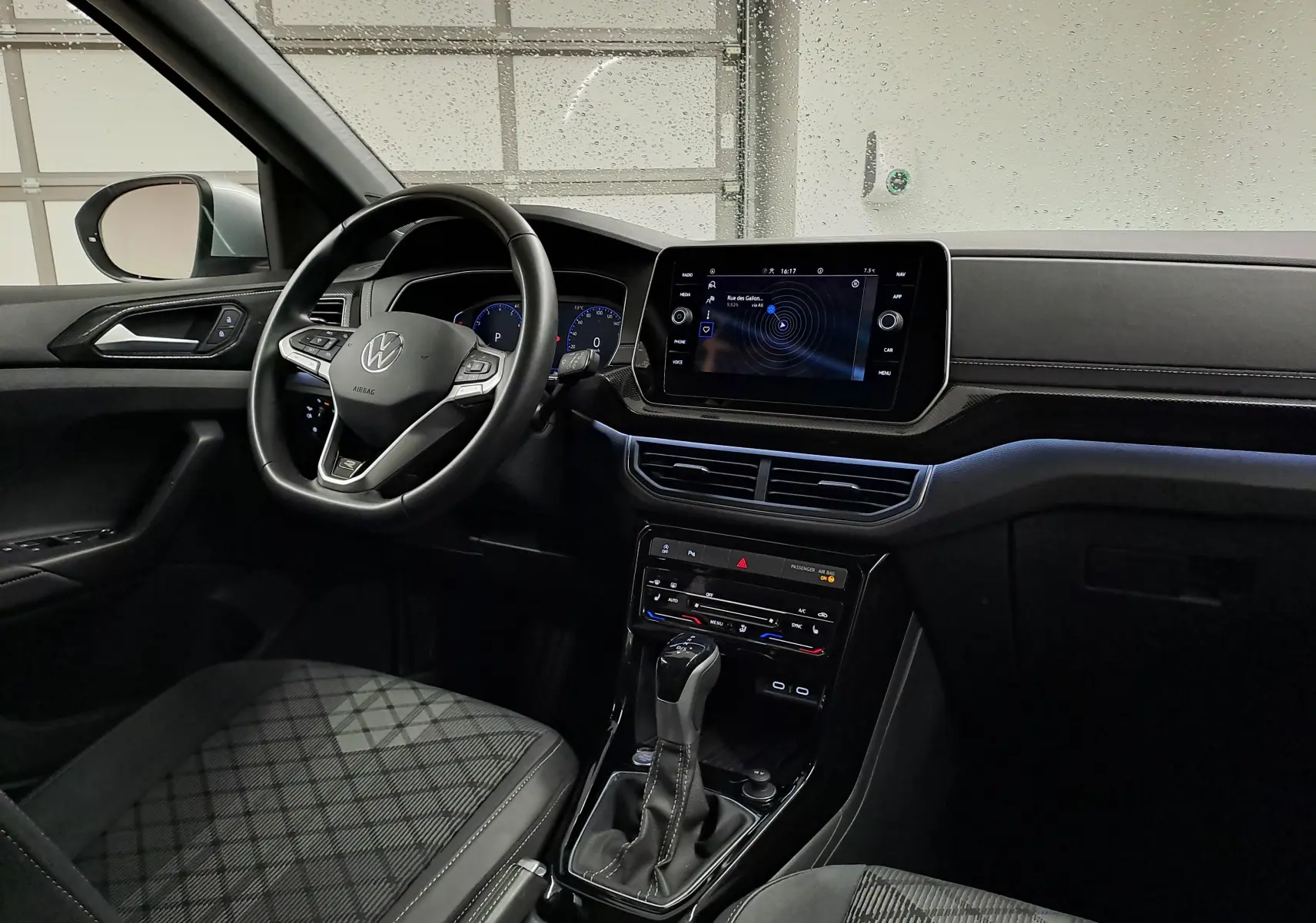 Vue intérieure côté conducteur du Volkswagen T-Cross 2025 R-Line Edition, mettant en valeur le volant multifonction et l'écran tactile central.