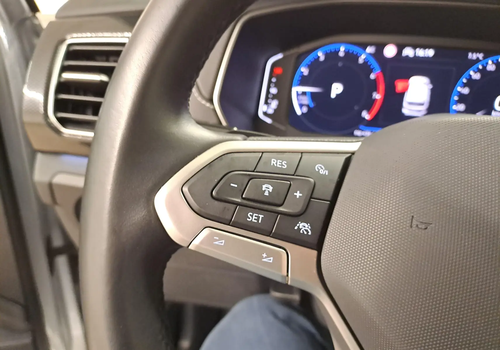 Gros plan sur le volant côté gauche du Volkswagen T-Cross 2025 avec commandes intégrées et tableau de bord numérique.