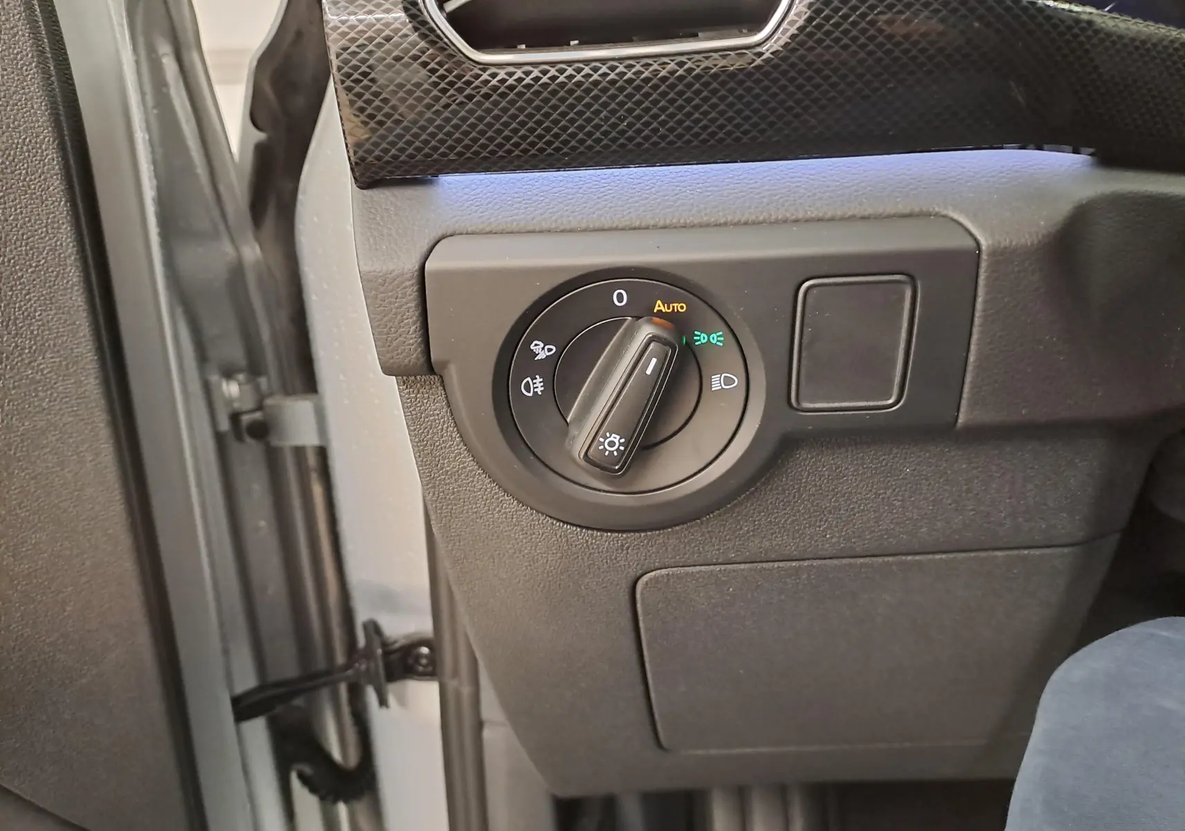 Gros plan sur le sélecteur d'éclairage intérieur du Volkswagen T-Cross 2025, côté gauche, avec finition R-Line Edition.